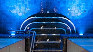 A spa area with a tiled wall, a seating area, and a water feature. - The Well Spa & Hotel (Nordre Follo)