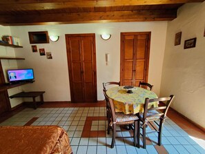 Traditional room with a dining area, television, and warm atmosphere.