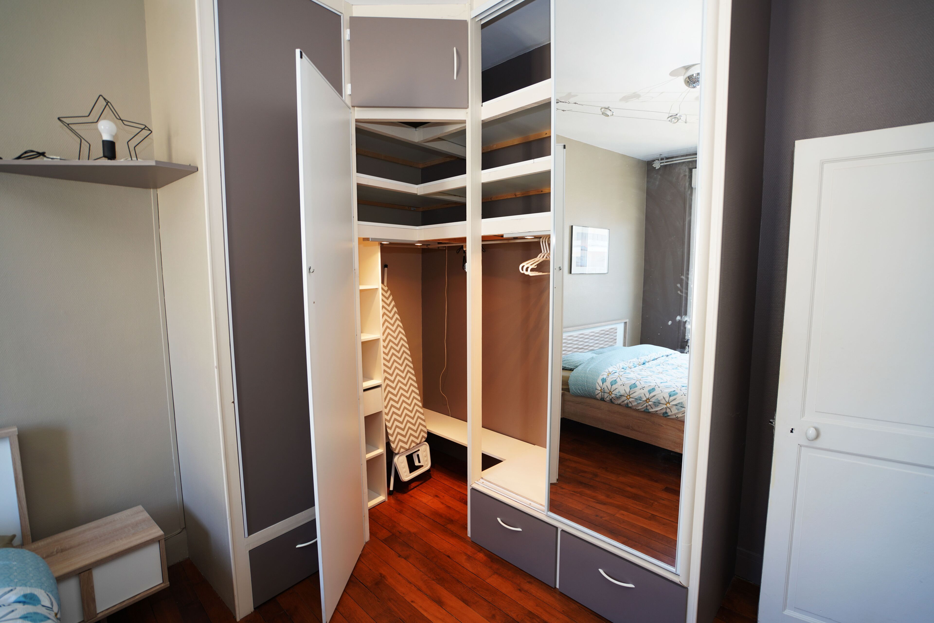 Une chambre à coucher avec un lit, une armoire et un miroir.