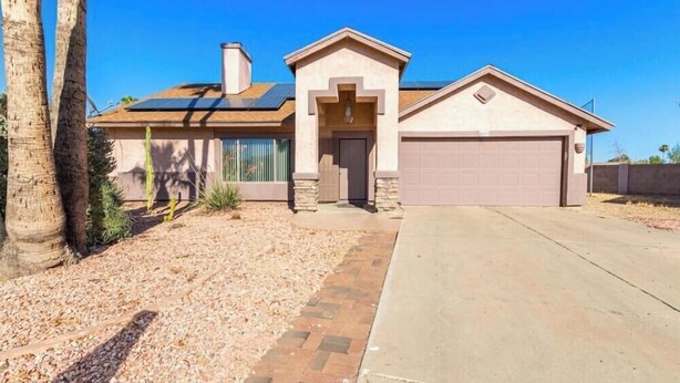 A single-story house with a garage, a front door, and a small porch. - Pool home in Phoenix Retreat close to everything! (Phoenix)