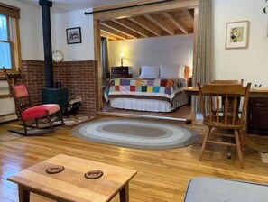 Relax in a traditional room with a comfortable bed, brick fireplace, and cozy wooden accents.