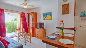 A room with a dining area, a television, a cabinet, and a ceiling fan. - Shangrila by Interhome (Calpe/Calp)