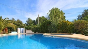 A clear blue swimming pool surrounded by lush greenery and palm trees. - Shangrila by Interhome (Calpe/Calp)
