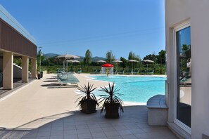 A pool area with lounge chairs and umbrellas, a clear sky, and a mountainous backdrop. - Sophistication in the Heart of Cilento: Villa with Garden and Dream Pool! (Campania)
