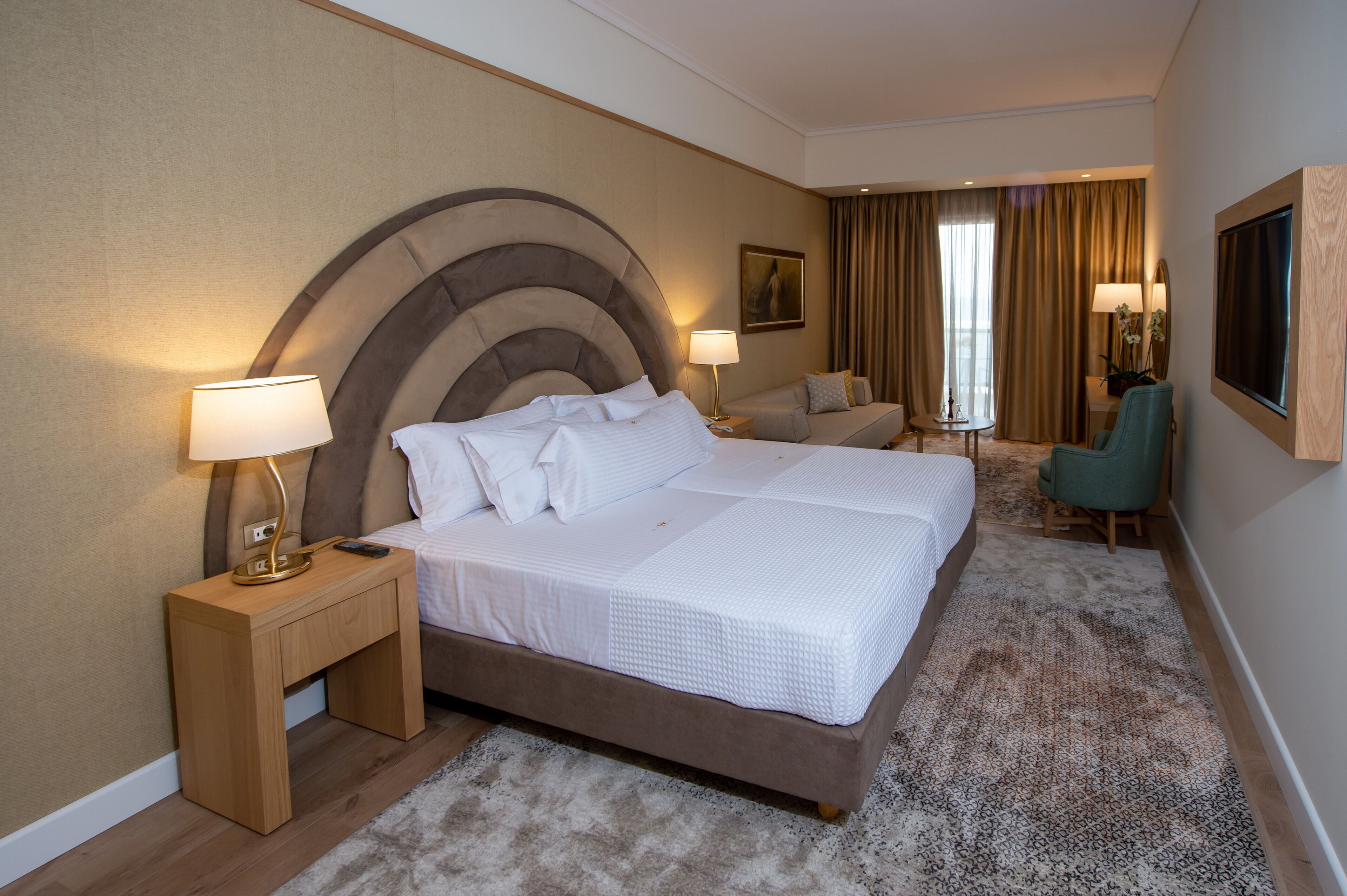 Une chambre d’hôtel avec un grand lit, un bureau, une chaise et un téléviseur.