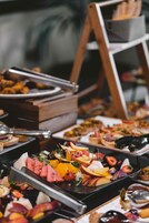Un bufé con diversas opciones de comida y un atril de madera con pan.