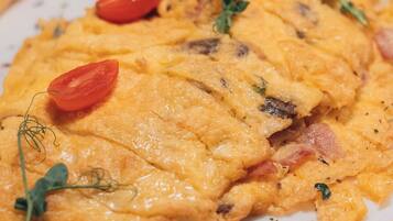 Une vue rapprochée d’un plat dont la croûte est dorée, agrémenté d’herbes et de tomates cerises.