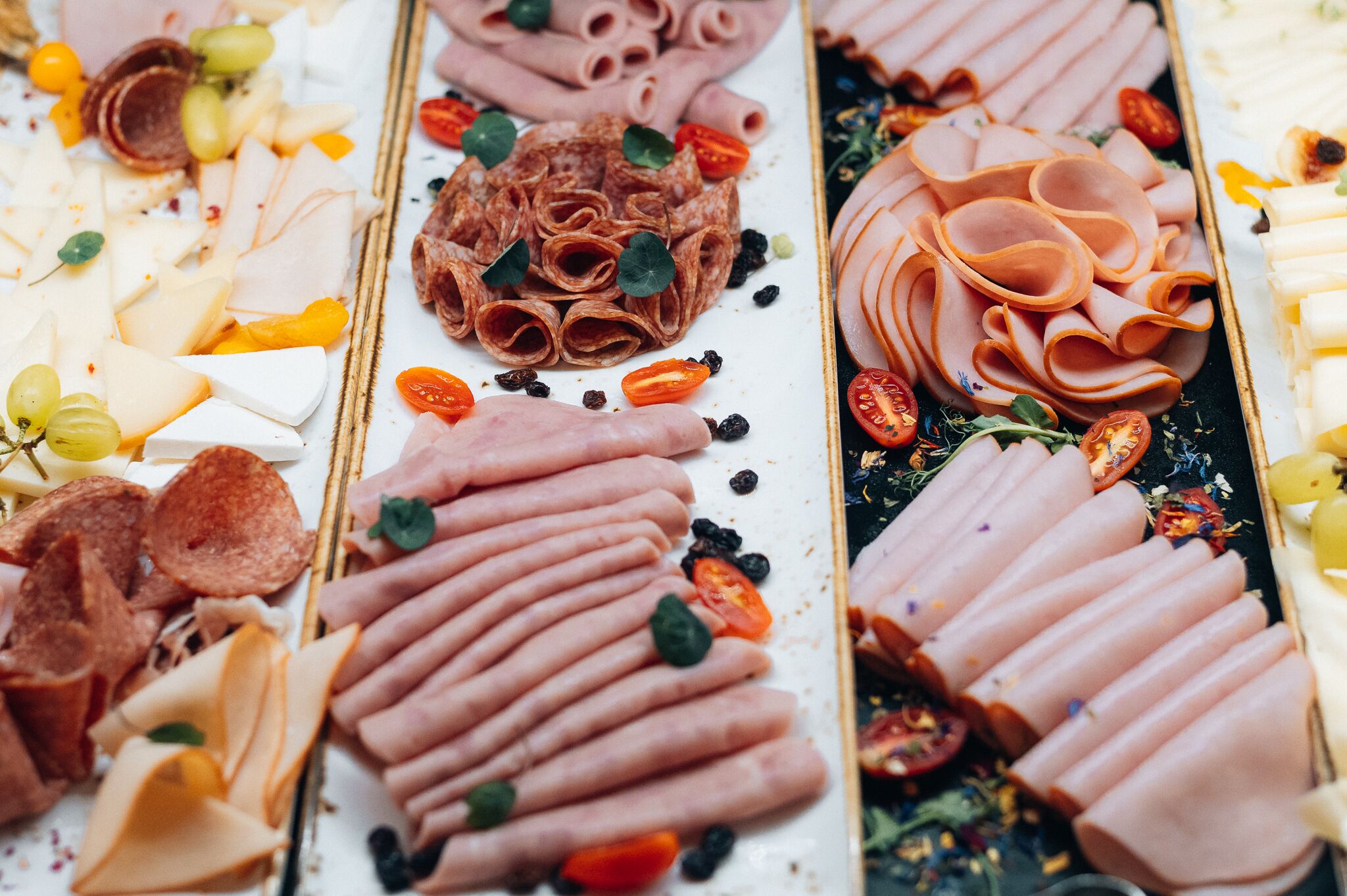 A variety of cheeses and meats arranged on a platter.