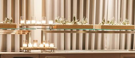 A modern dining area with a long table, chairs, and a decorative cactus display.
