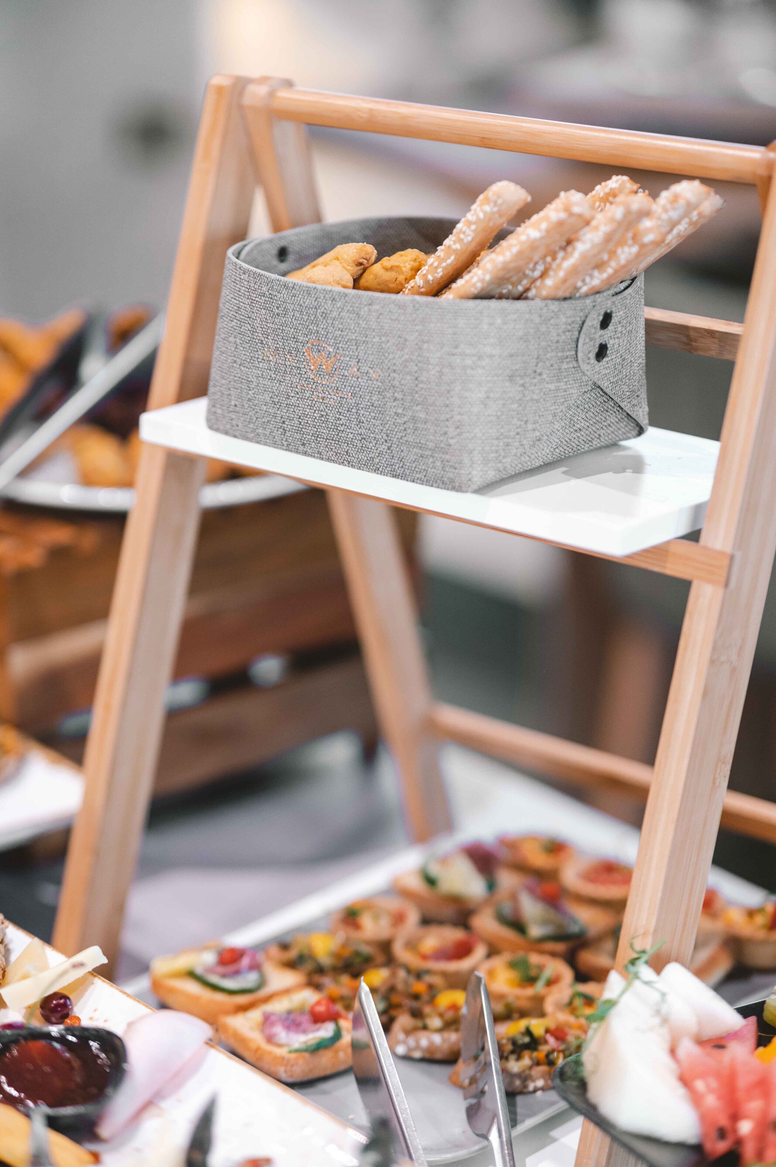 A buffet table with various food items, including breadsticks and assorted appetizers.