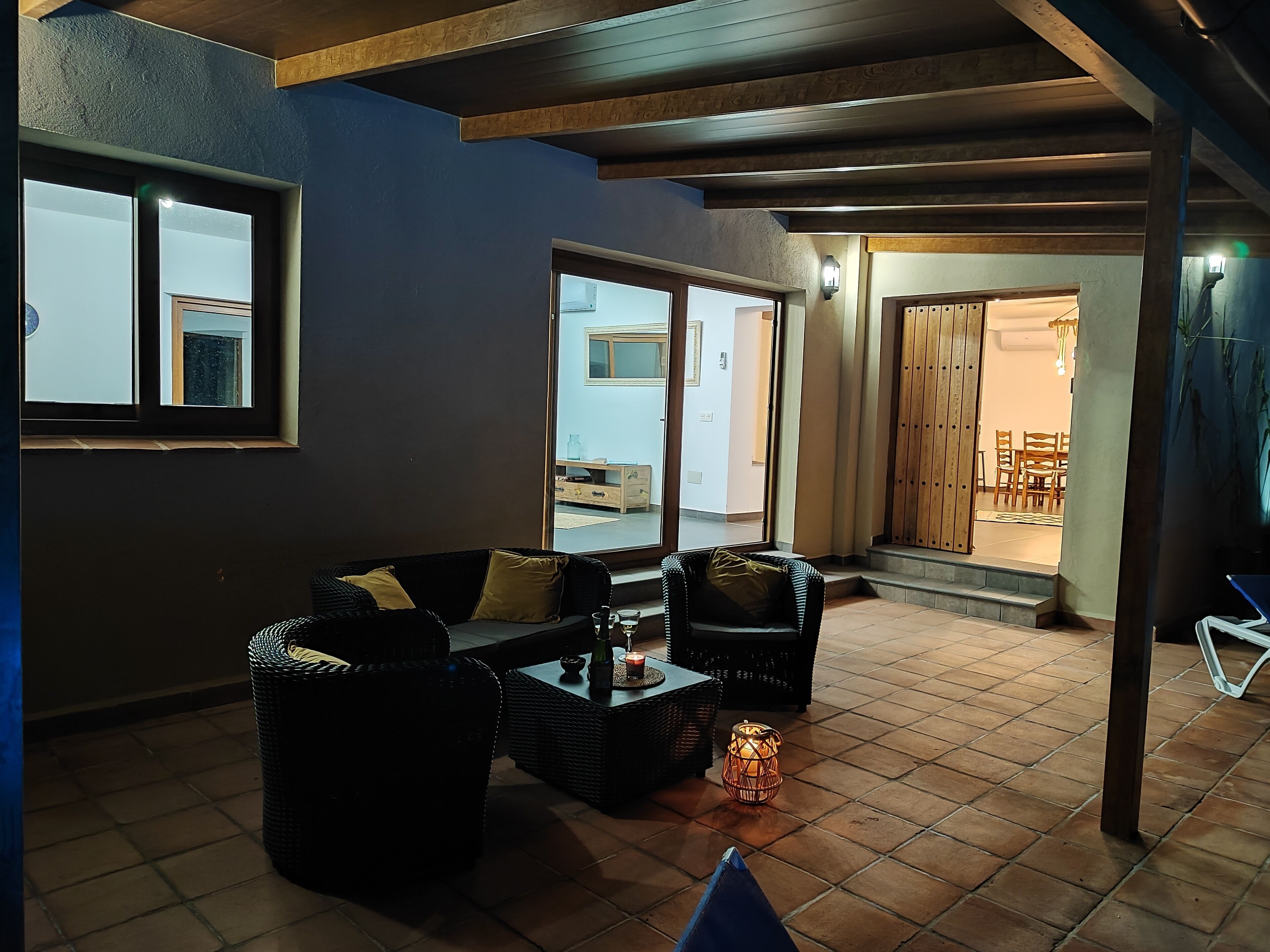 A cozy indoor seating area with wicker furniture and a tiled floor.