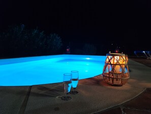 A swimming pool at night with two glasses of water and a lit lantern. - Villa Las Adelfas with beautiful view ,HEATED POOL, 6 Pers, WIFI,BBQ,terraces (Benamargosa)