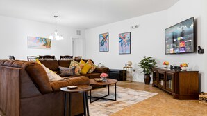 A living room with a sofa, coffee table, TV, and artwork on the wall. -  A-POP of Sunshine  (Davenport)