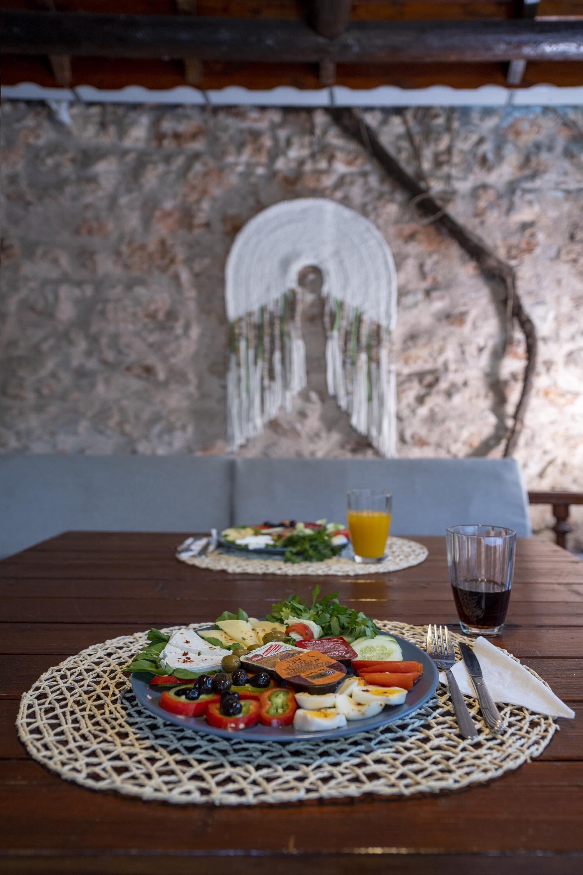 Una mesa con un plato de comida, un vaso de jugo y un tenedor y un cuchillo.