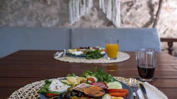 A table with a plate of food, a glass of juice, and a fork and knife.