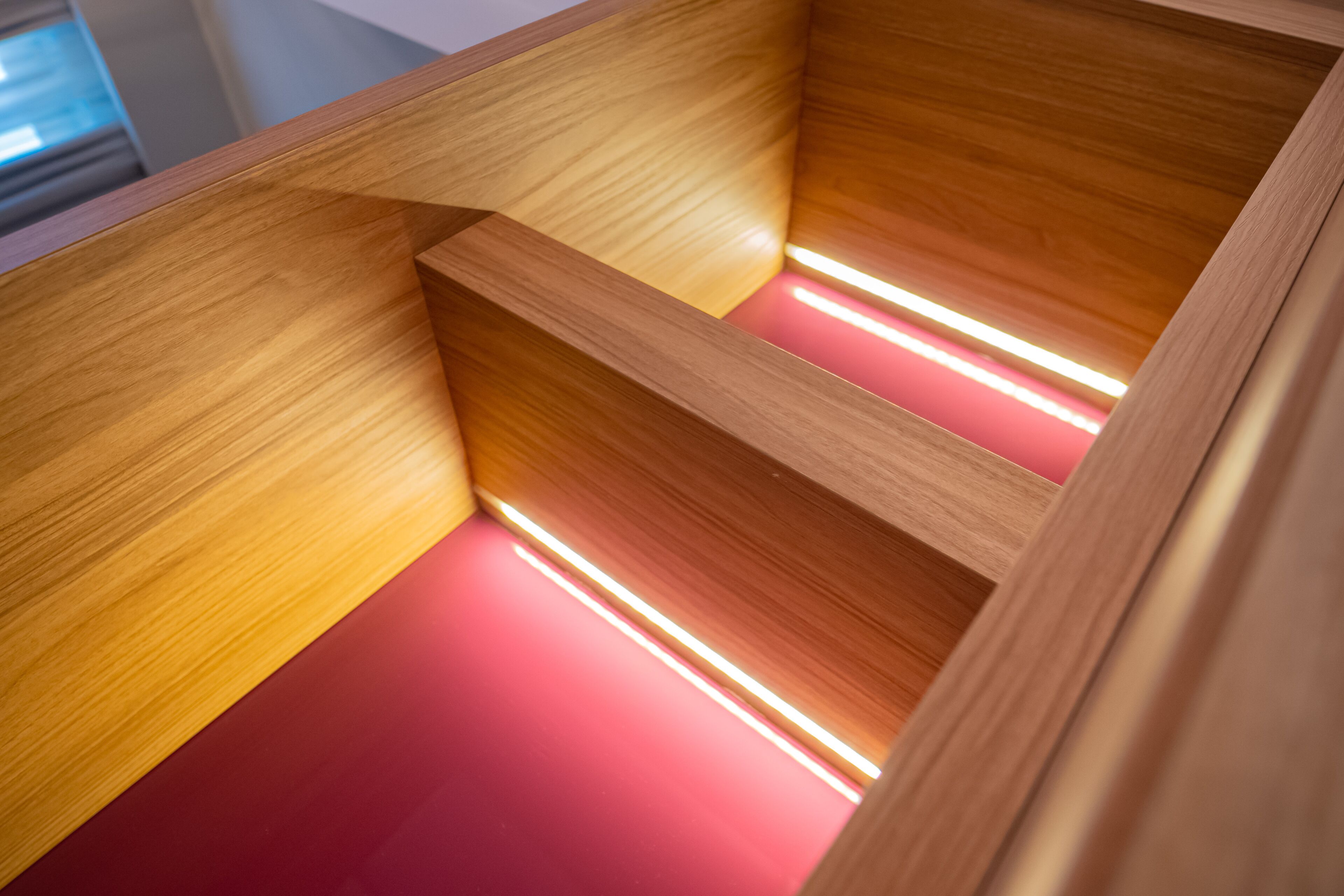 A wooden interior with a red floor and a light strip running along the edge.