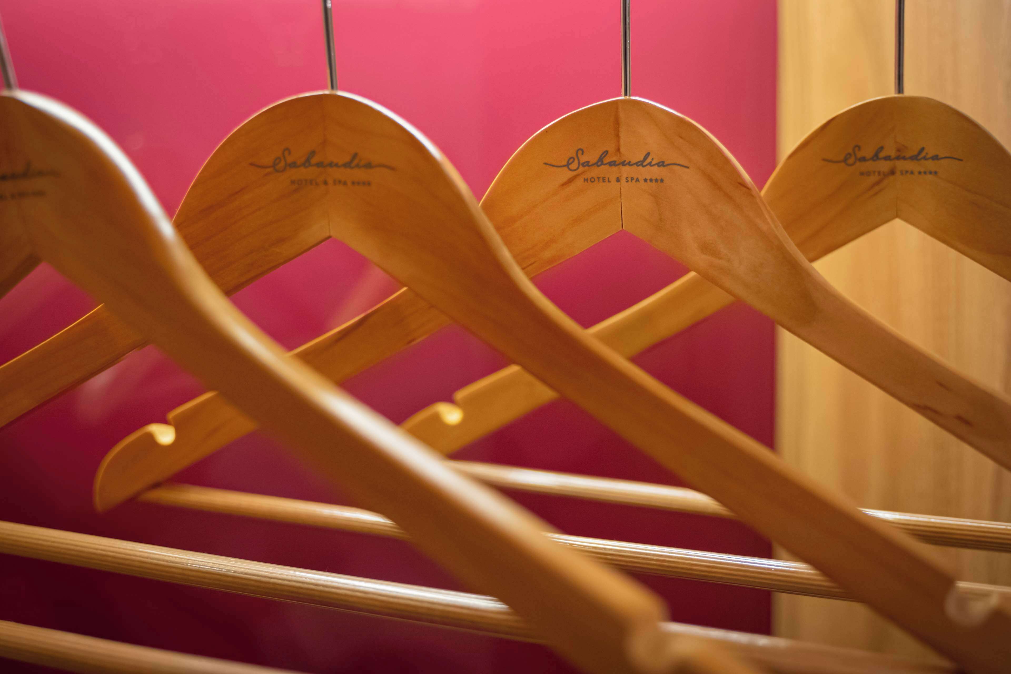 A row of wooden chairs with the name "Sabandia" engraved on the backrests, indicating a branded seating area.