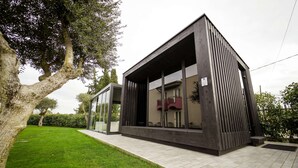 Un bâtiment moderne doté d’un toit plat, de grandes fenêtres et d’un trottoir dallé.