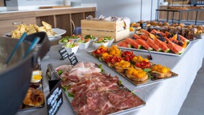 Un buffet proposant une variété de plats, notamment des viandes, des fromages et des fruits.