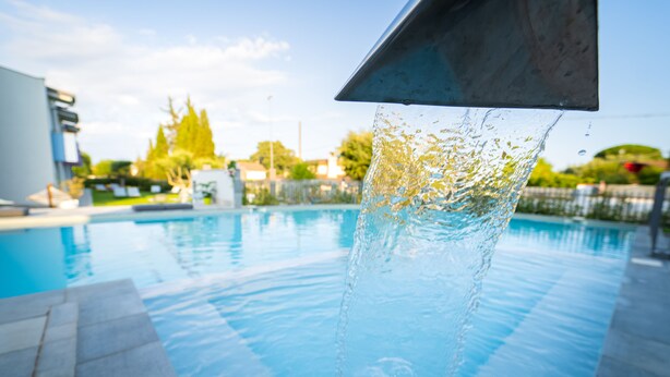 Une piscine à l’eau claire, avec une structure métallique en premier plan.