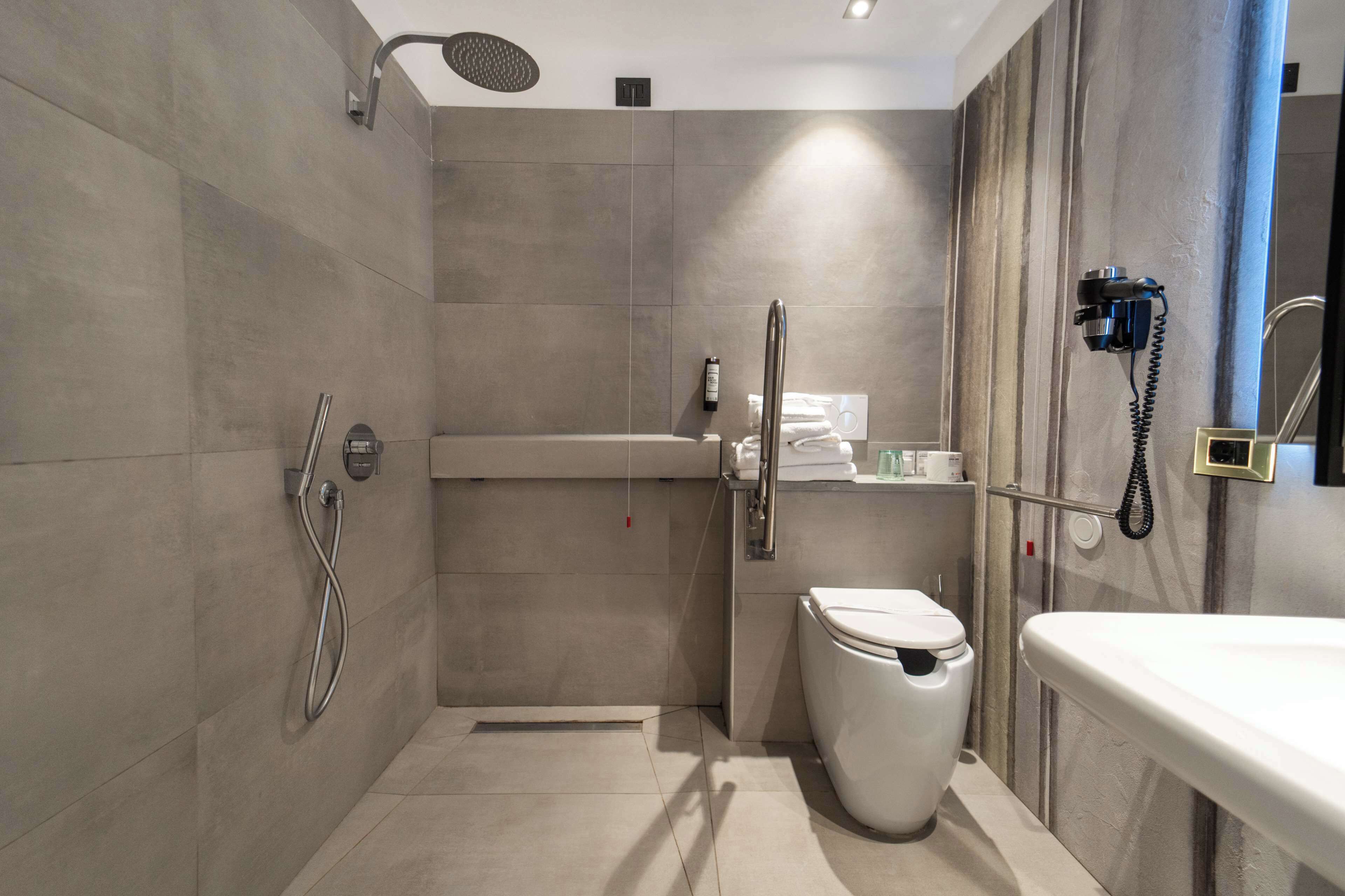 A modern bathroom with a walk-in shower, toilet, and sink.