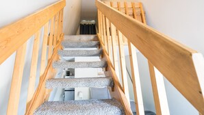 Una escalera de madera con peldaños alfombrados que conduce a una plataforma.