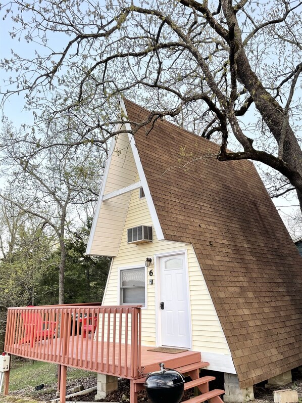 A small, triangular-shaped cabin with a red deck and a chimney. - A-Frame Cabin on Table Rock Lake- by SDC! (Branson)