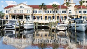 A waterfront hotel with a docked boat, a restaurant named "Pinchert's Crab Shack," and a bell tower. - Romantic vacation spot by the water with private heated pool and spa, kayaks! (Cape Coral)