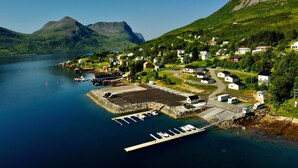 A coastal village with houses, a dock, and boats. - Senja Fjordcamp - Senja by Heart (Torsken)