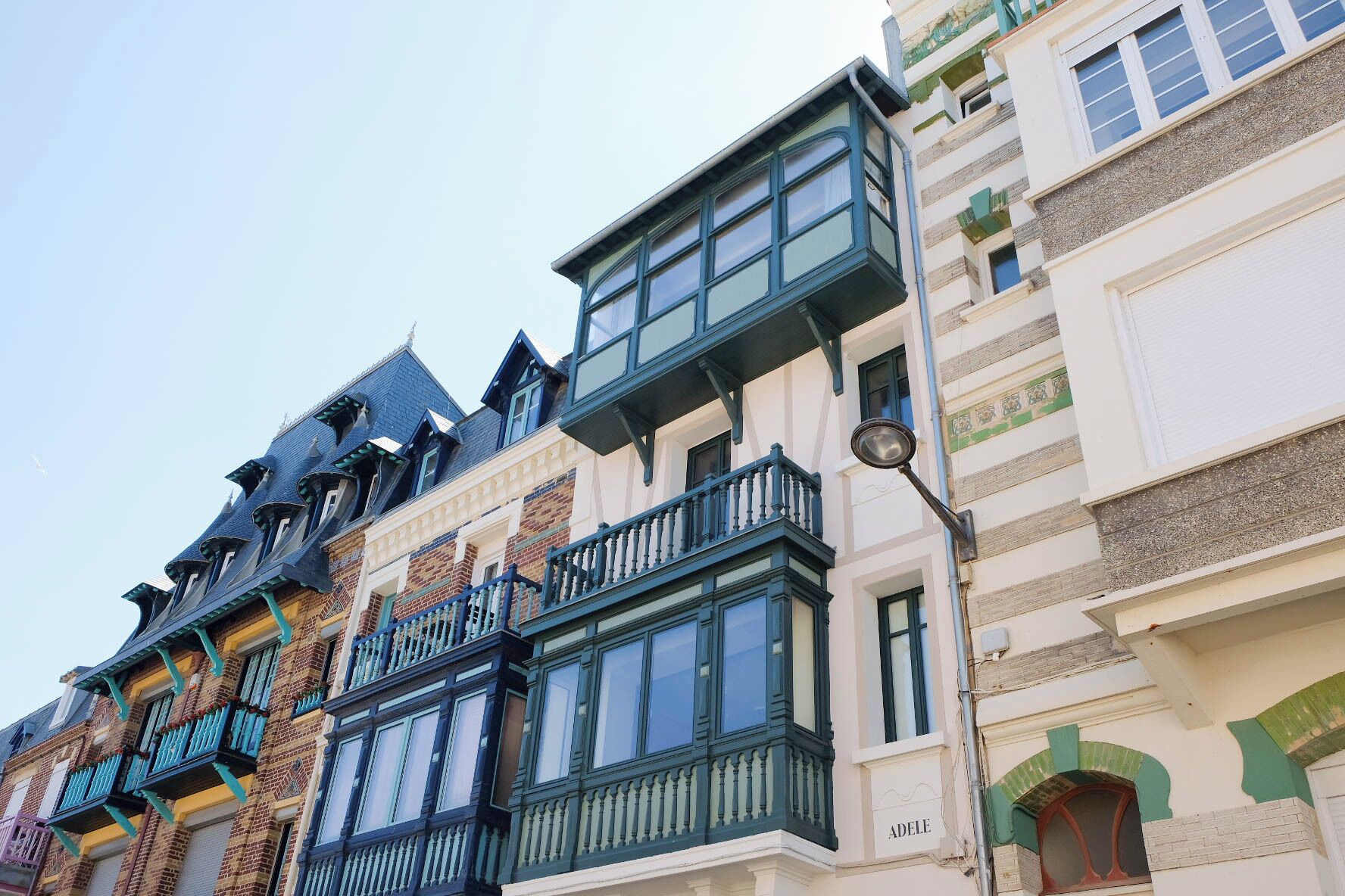 Une rangée d’immeubles à étages, dotés d’une architecture européenne traditionnelle, avec de larges balcons et de grandes fenêtres.