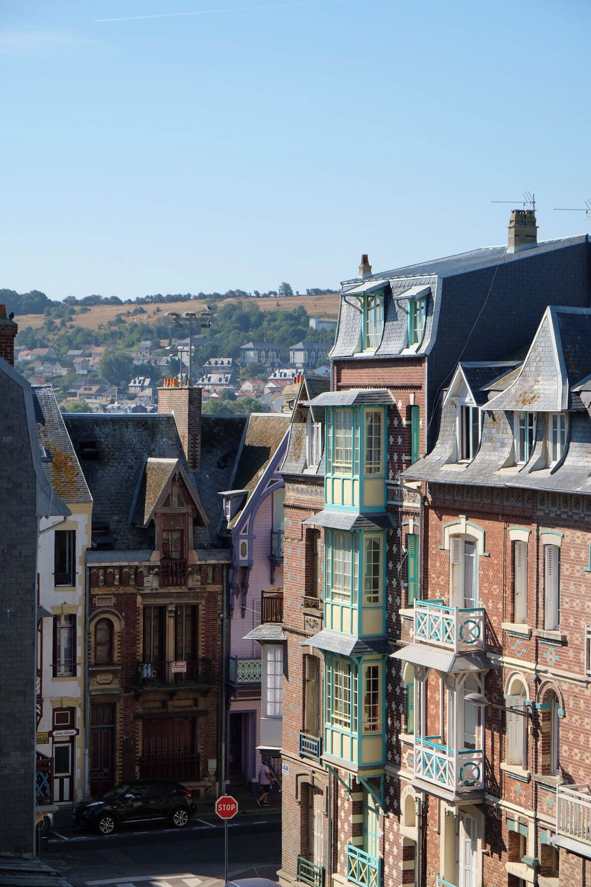 A street view with traditional European architecture, including buildings with steep roofs and decorative elements.
