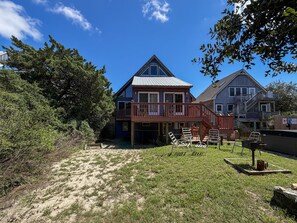 A two-story house with a deck and a covered outdoor seating area.