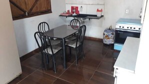 Eine kompakte Küche mit Esstisch und Stühlen, einem Herd und einem Kühlschrank.