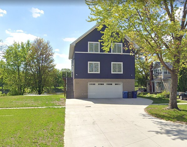 A two-story house with a garage, a front yard, and a driveway.