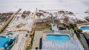 Un resort con playa, zona de piscina y torre de salvavidas.