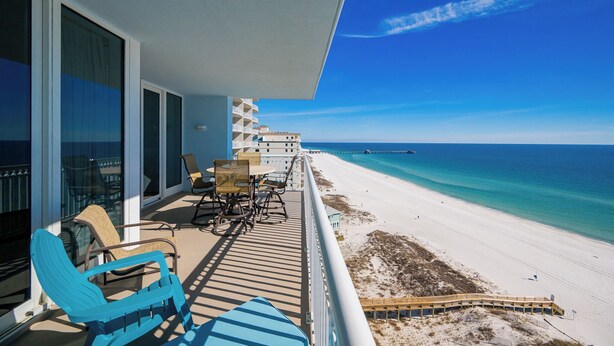 Un balcón con mobiliario de exterior con vista a la playa.