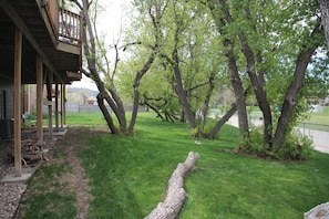 Enjoy a serene backyard retreat with a spacious deck, lush lawn, and mature trees.