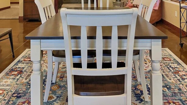 Un coin repas avec une table et des chaises en bois, une bibliothèque et un canapé.