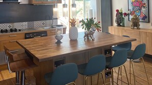 A modern kitchen with a large island, bar stools, and a dining area with a table and chairs. - Nice town house, 4 mn from Bordeaux Rive droite Private swimming pool (Cenon)
