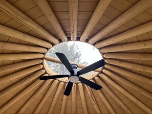 Stunning circular ceiling with a central fan, surrounded by radial wooden beams.