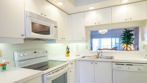 A modern kitchen with white cabinets, a built-in microwave, a stove, and a dishwasher. - Perico Bay Club · 30-Night Min · Intracoastal (Bradenton)