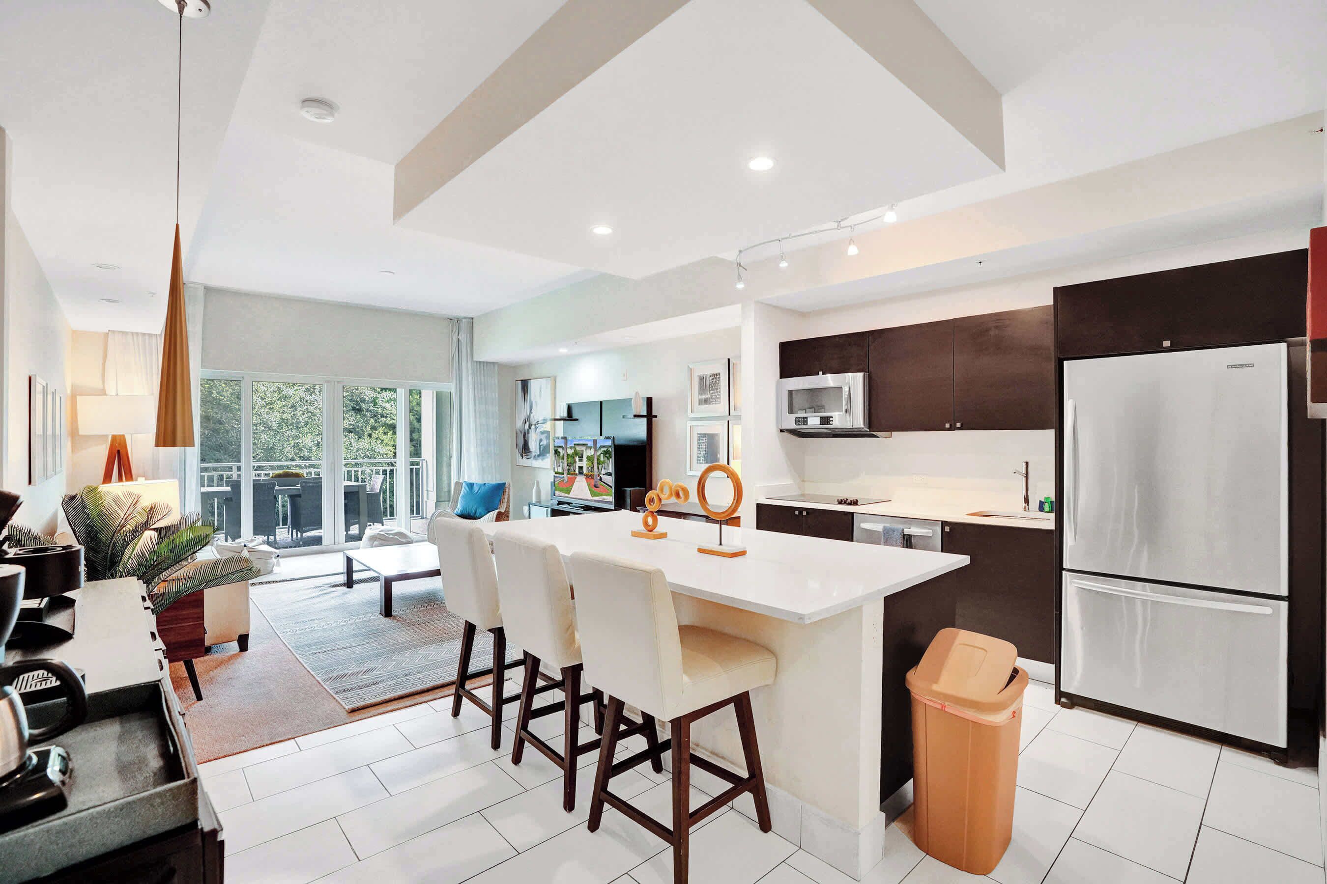 A modern kitchen with a central island, stainless steel appliances, and a view to the outdoors.