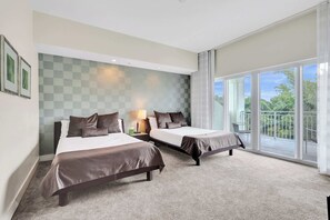 Een hotelkamer met twee bedden, een groot raam met balkon en een geruit muurontwerp.