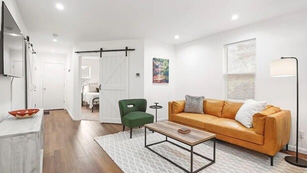 A modern living room with a leather sofa, a green armchair, and a coffee table.