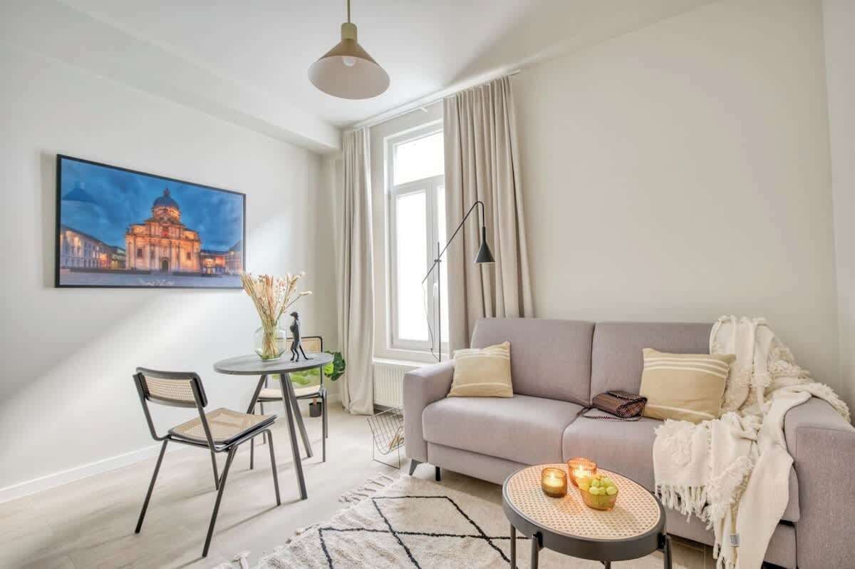 The lovely living room area complete with a small dining set, sofa couch, cozy area rug, coffee table, and a lamp making for an ideal reading set up.