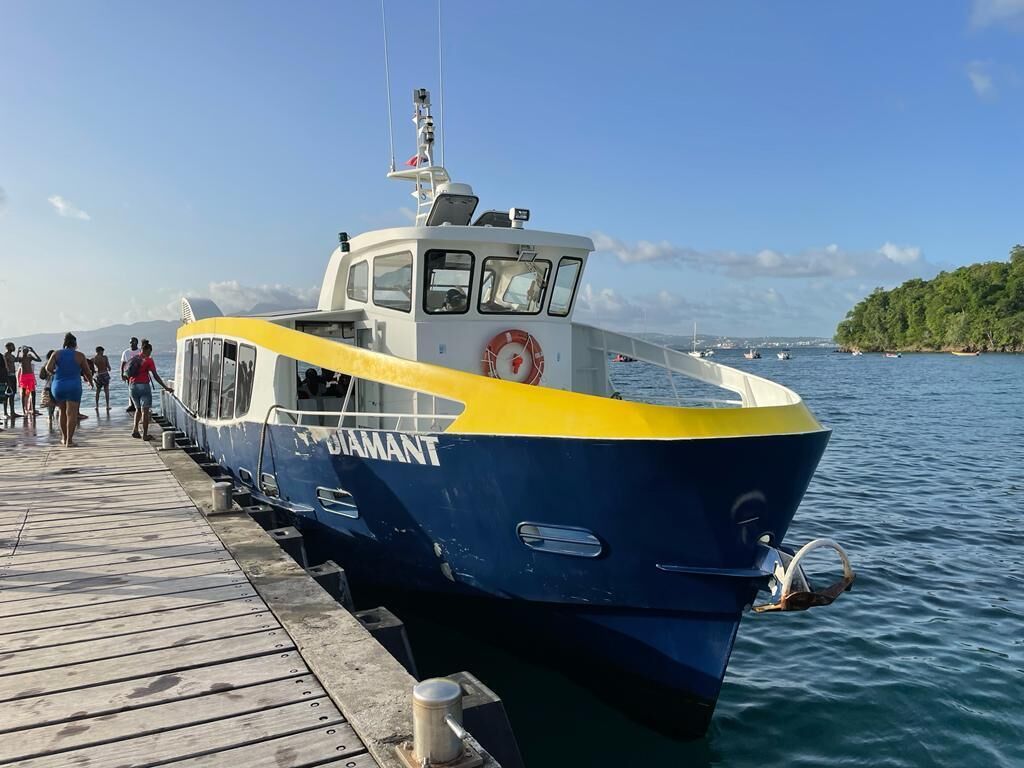 A boat docked at a pier with people boarding.