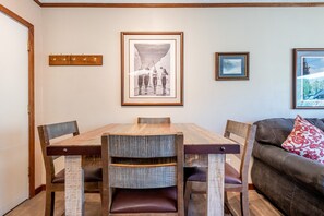 A dining area with a wooden table and chairs, a coat rack, and framed pictures on the wall. - Amazing Copper Mountain Views, free wifi, free parking. Telemark Lodge studio (Copper Mountain)