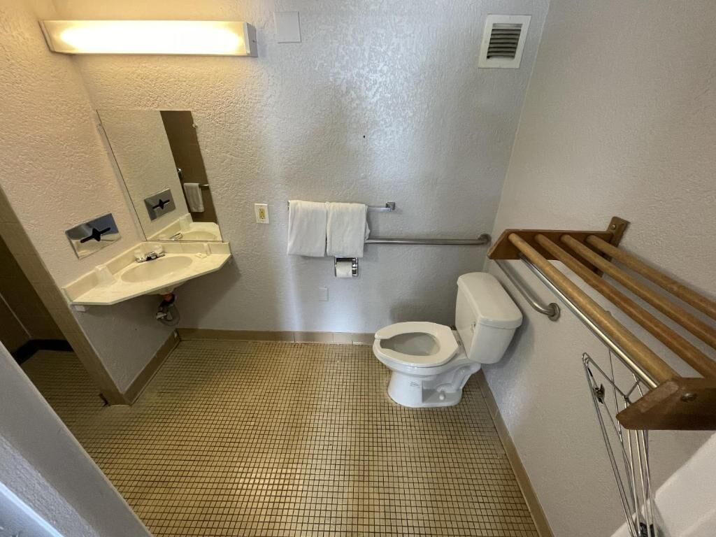 Un baño pequeño con inodoro, lavamanos y espejo.