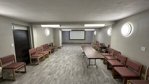 A conference room with a long table and chairs arranged for meetings. - Rodeway Inn Albuquerque West (Albuquerque)
