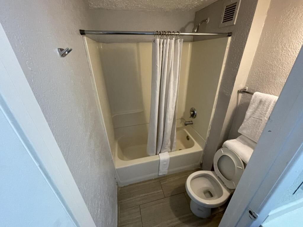 A bathroom with a bathtub, shower, and toilet.